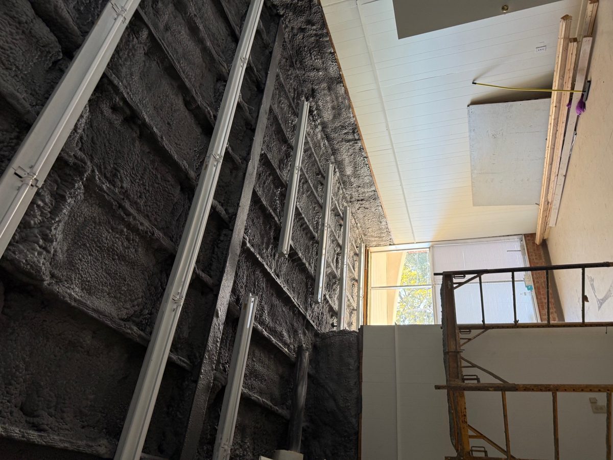 Dark dyed open-cell spray foam on a commercial ceiling