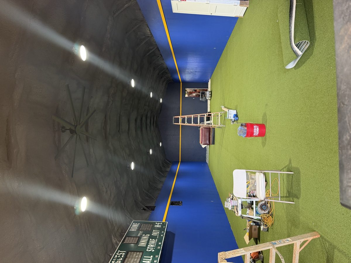 Dyed open-cell spray foam ceiling in an indoor batting facility